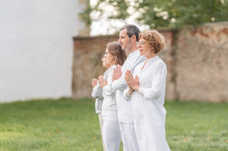 Alana beim Kundalini Yoga mit Teilnehmern im Garten